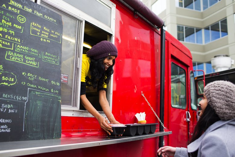 Shama Joshi (cq), of the food truck Roll OK Please, serves a customer during lunchtime on the campus of T-Mobile in Bellevue.